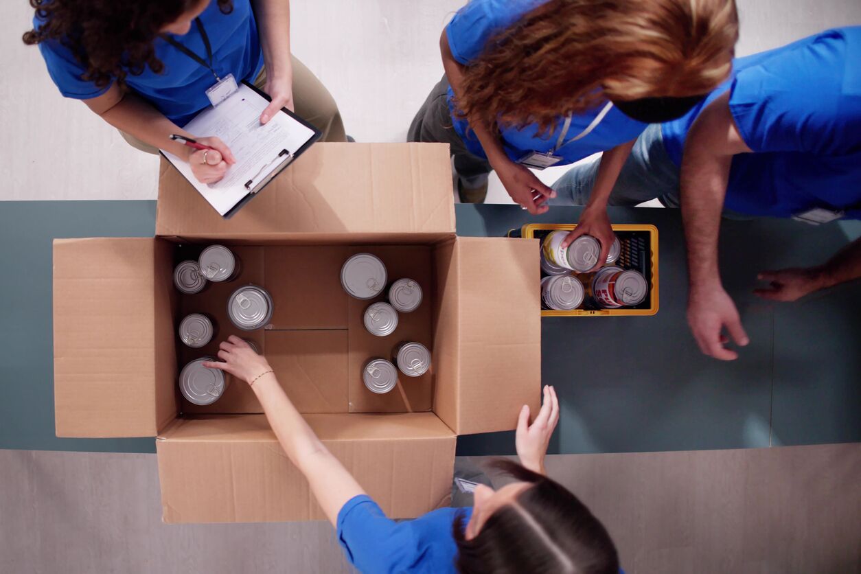 Diverse group of volunteers packing donation boxes for food bank